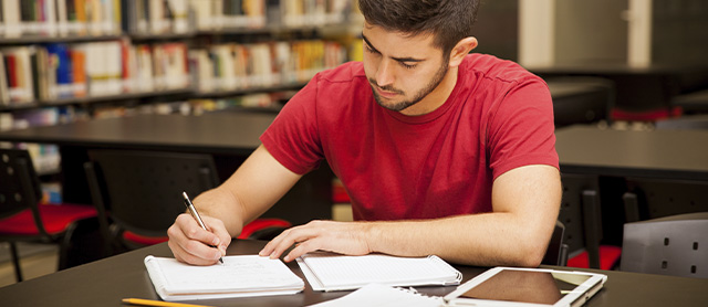 homem estudando na biblioteca