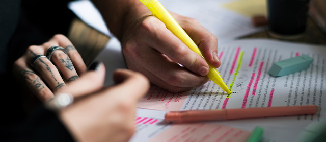 pessoa estudando em grupo, destacando trechos do texto com marca-texto