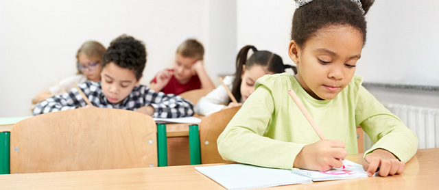menina na escola escrevendo com um lápis, um dos intens que não pode faltar no estojo escolar