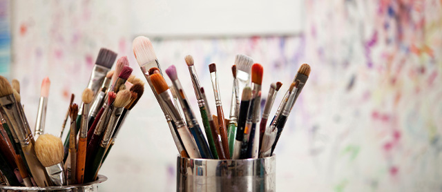 vários tipos de pincéis em uma lata em um ateliê de pintura