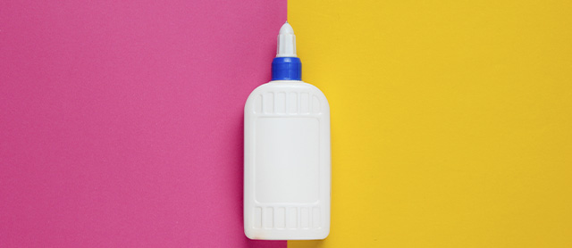 tubo de cola escolar sobre um fundo rosa e amarelo