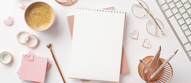 cadernos, canetas, clipes e outros itens de papelaria fofa em formato de coração, todos em tons de rosa pastel
