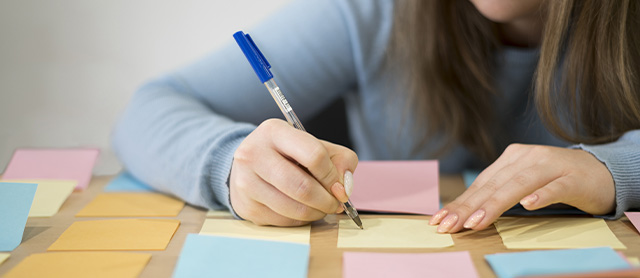 garota estudando e fazendo anotações em blocos de anotações